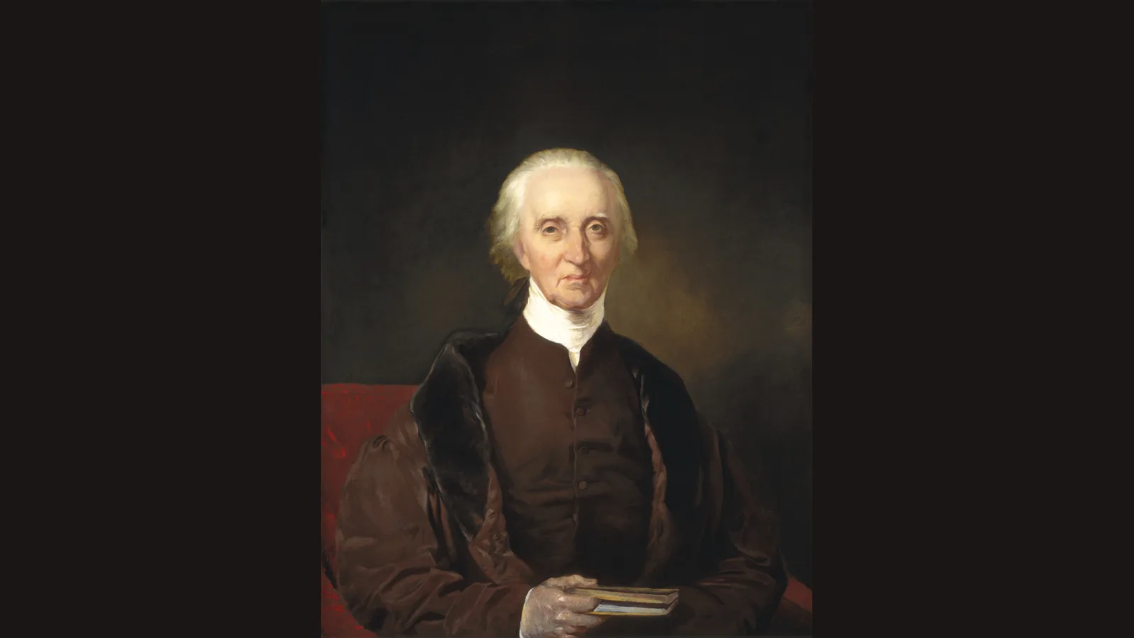 Oil portrait of an elderly man with white hair in a dark brown coat, a robe trimmed with fur and a white neckcloth, seated in a red chair and holding a small book; public domain portrait credited below.